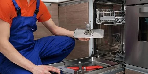 Technician removing and inspecting a dishwasher pump assembly