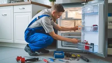 Technician inspecting a refrigerator during an appliance service visit